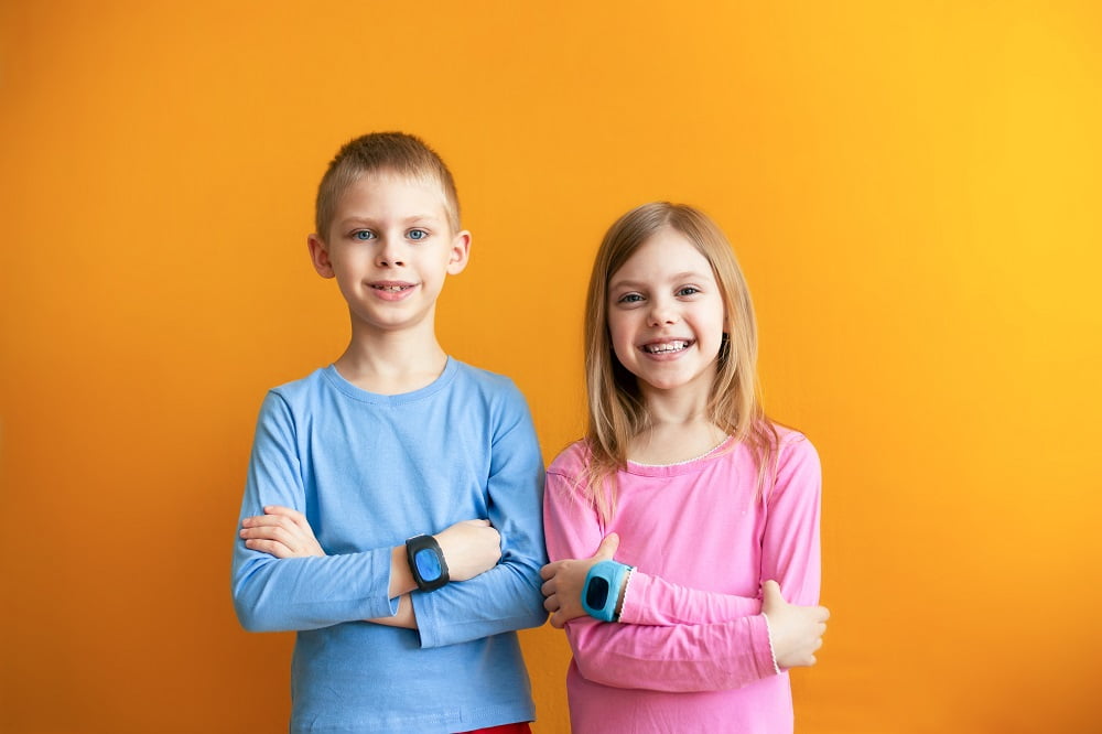Happy Children 6 8 Years Old With A Smart Gps Watch Talking To Parents Safely. Orange Background